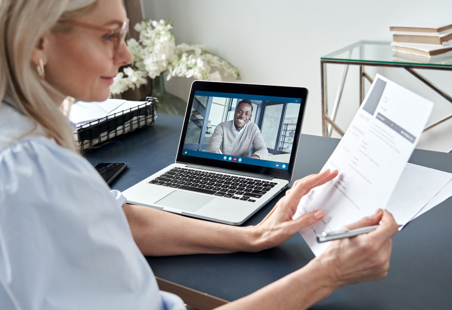 Woman interviews via video call with resume.
